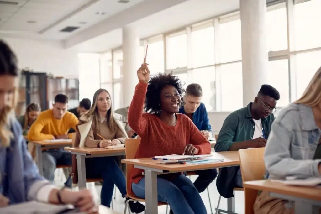 Student of colour raising their hand up in class